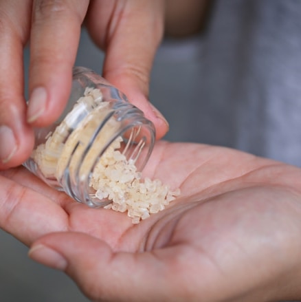 Hand holding salts, representing synthetic drugs, implying the necessity to let go for a healthier life.