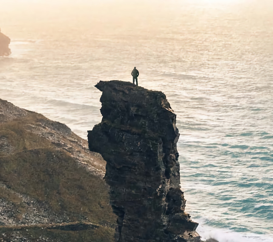 Man standing on an ocean spire, symbolizing the courage and determination required in the journey to overcome fentanyl addiction