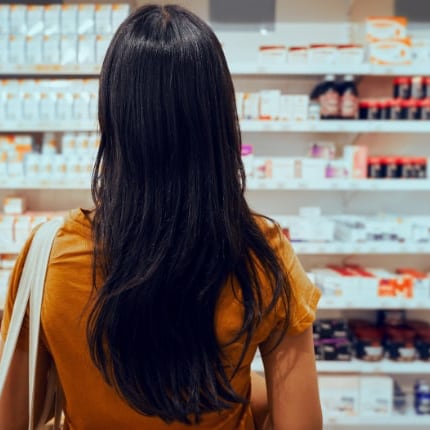 Woman contemplating multiple pill bottles, representing the struggle and determination to go to prescription drug rehab in Arkansas