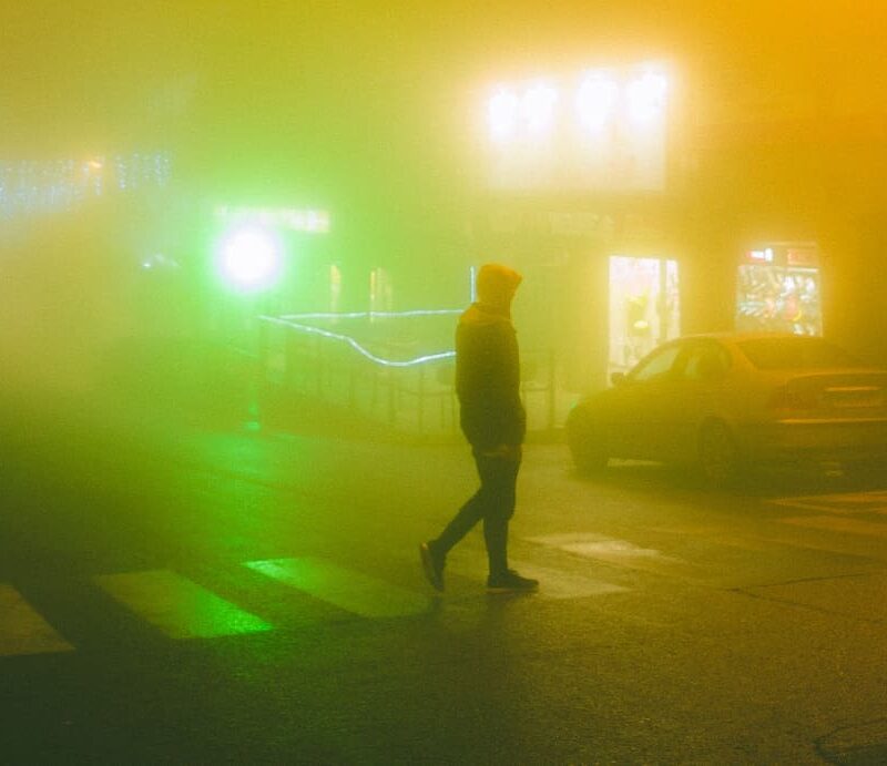 1. Man walking away into fog on a city street: A lone man walks away into a misty city street, symbolizing the hazy journey of how drugs affect your appearance.
