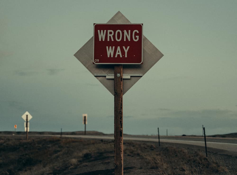 2. Wrong way sign on a road: A 'wrong way' sign on an open road, illustrating the dangerous path of letting drugs affect your appearance.