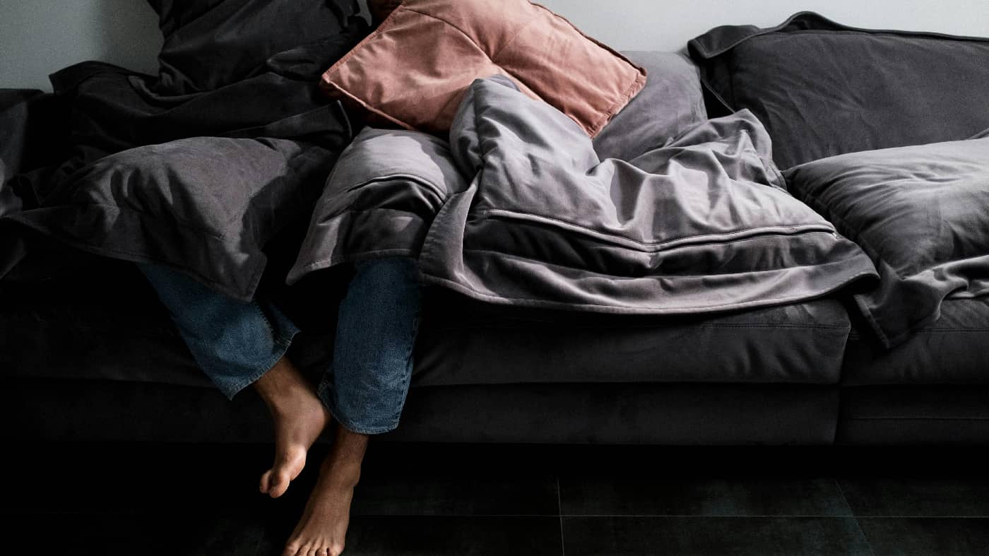 Image of a man struggling to rise from a couch, embodying the physical and emotional challenges faced by individuals dealing with Lexapro abuse.