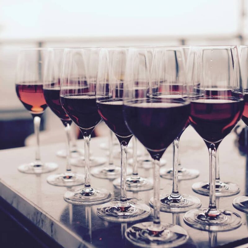 An array of empty wine glasses increasing in size to visually represent the concept of 'what is drug tolerance,' symbolizing how more of a substance is required over time to achieve the same effect.