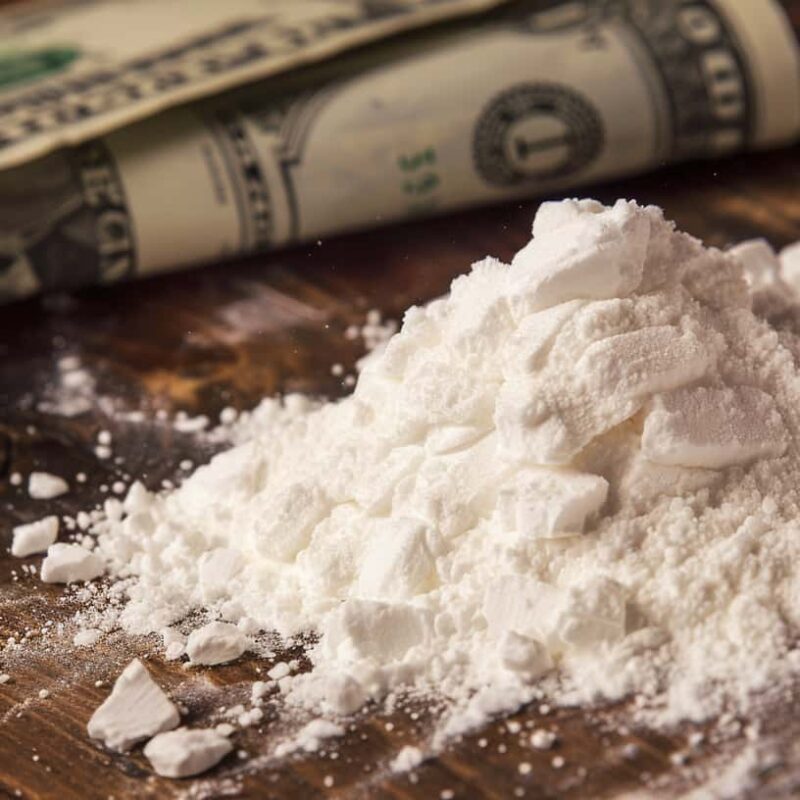 A line of powdered cocaine next to a crumpled dollar bill, illustrating “how much does cocaine cost?”