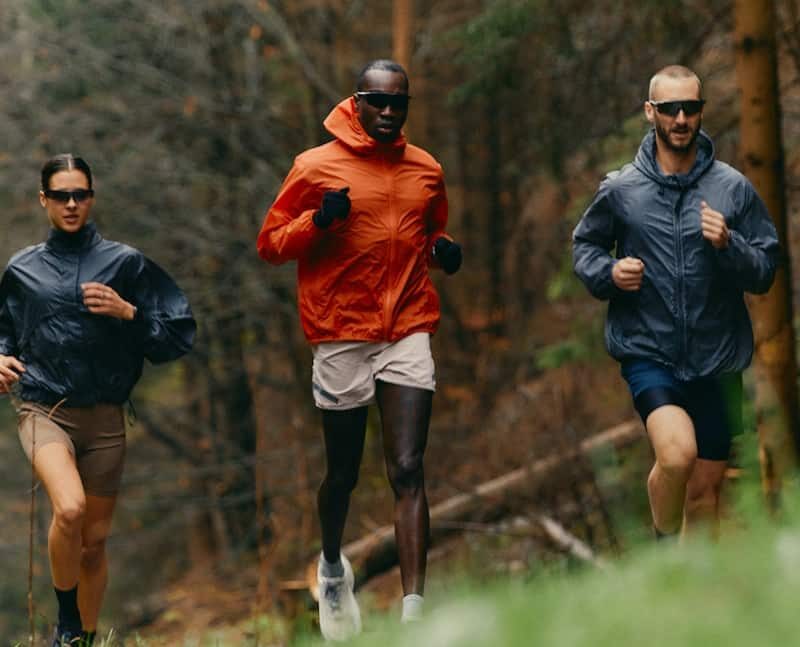 Three people jog on a forest trail showing the full life offered with rehab aftercare.