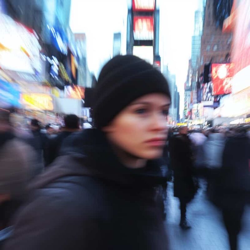 Woman in a city has blurred features along with the blurry background showing psychosis and schizophrenia caused by drugs