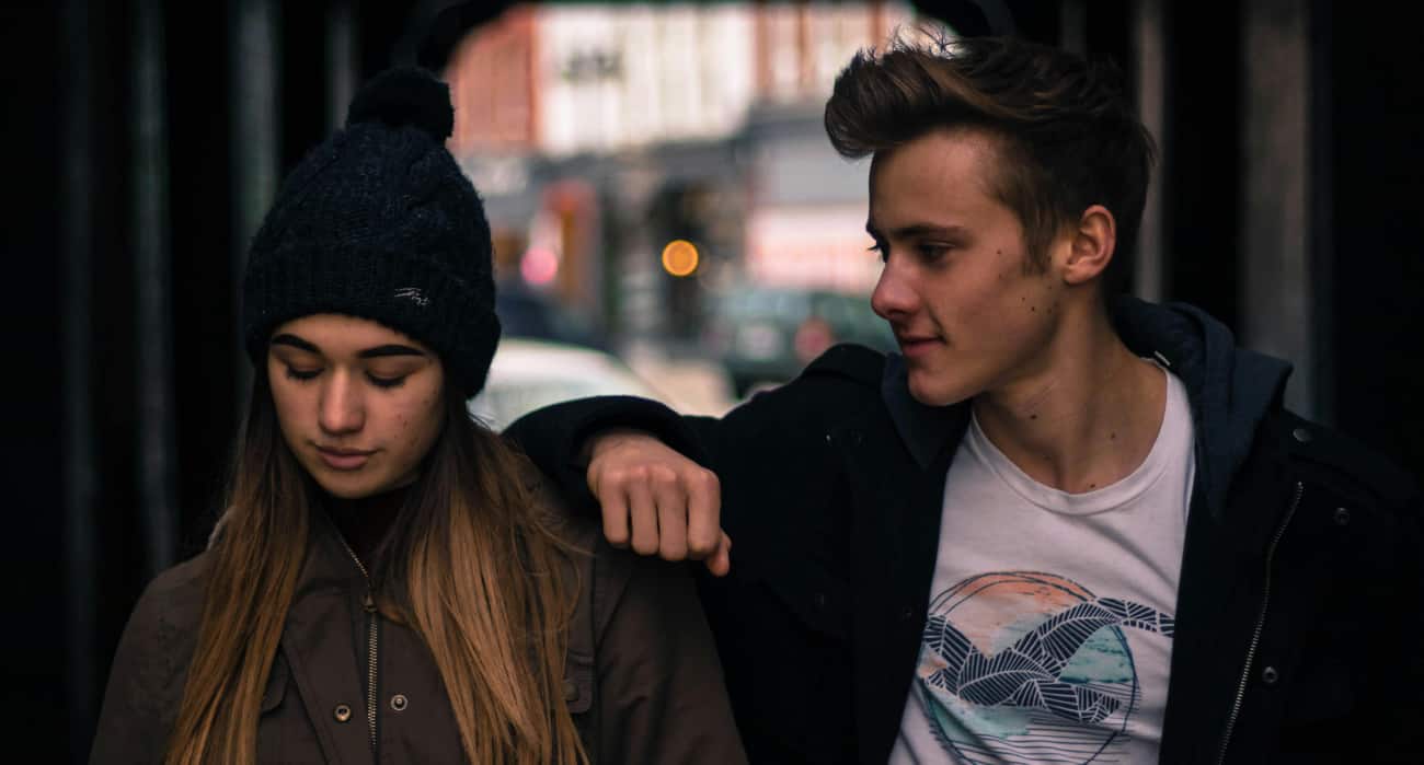 Young man and woman walk a street in Arkansas talking about short-term residential treatment for addiction.